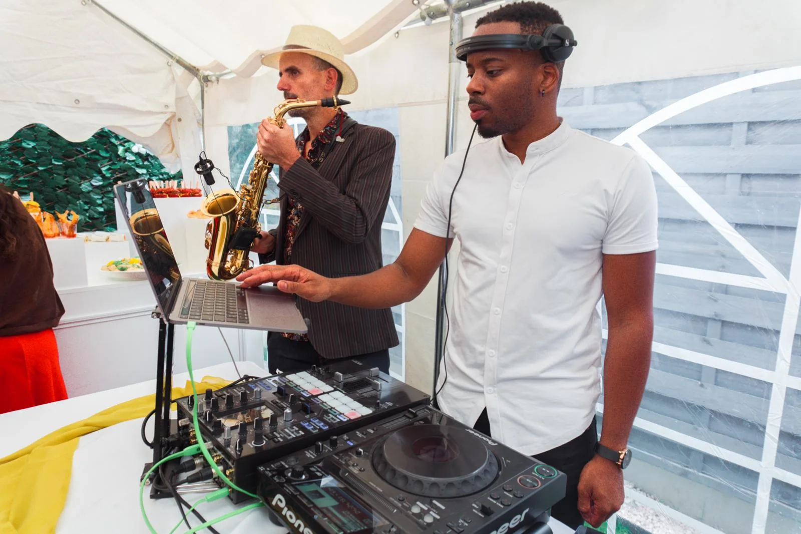 mikOsax joue du saxophone aux côtés d'un DJ aux platines pendant un anniversaire sous tente en Île-de-France